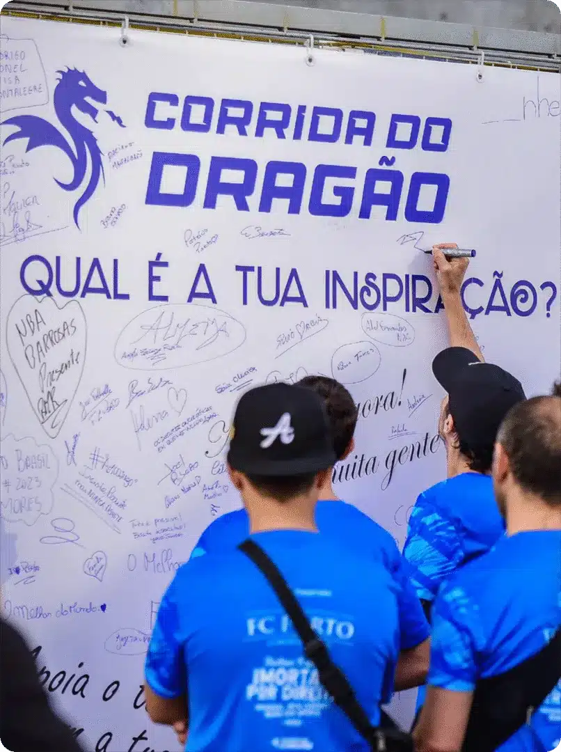 Pessoas escrevendo em um mural da Corrida do Dragão.